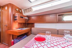A compact interior with a dining area, a kitchenette, and a seating area. - Sun-kissed Sailing Adventure in Istria, Croatia (Pomer)