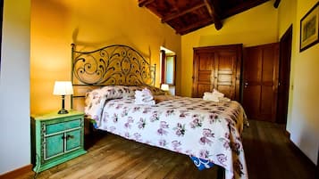 Een slaapkamer met een bed, twee nachtkastjes, een houten garderobe en een houten plafond.