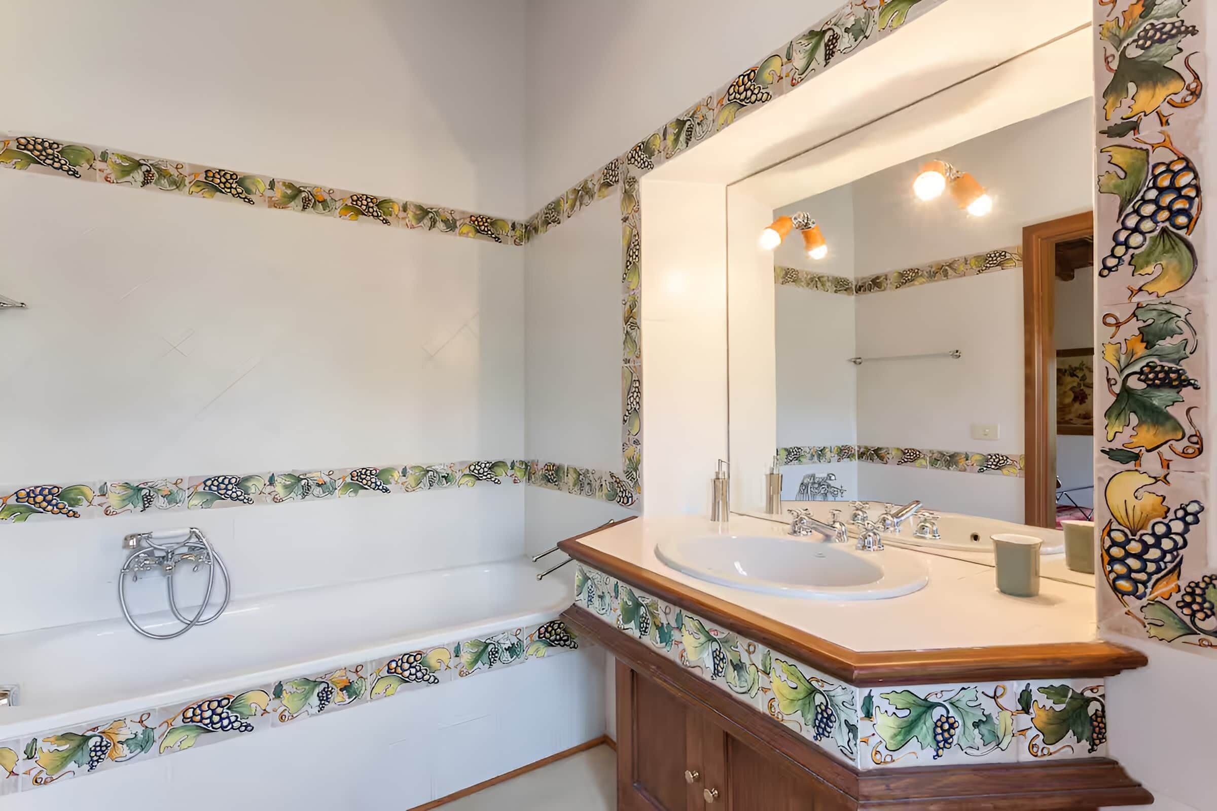 Un baño con bañera, lavabo y espejo.
