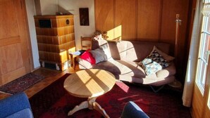 Ein gemütliches Wohnzimmer mit einer Couch, einem kleinen runden Tisch und einem Bücherregal.