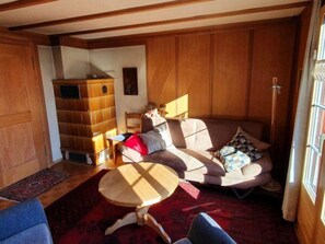 Ein gemütliches Wohnzimmer mit einer Couch, einem kleinen runden Tisch und einem Bücherregal.