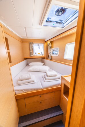 Una cabaña acogedora con cama, una ventana pequeña y un tragaluz.