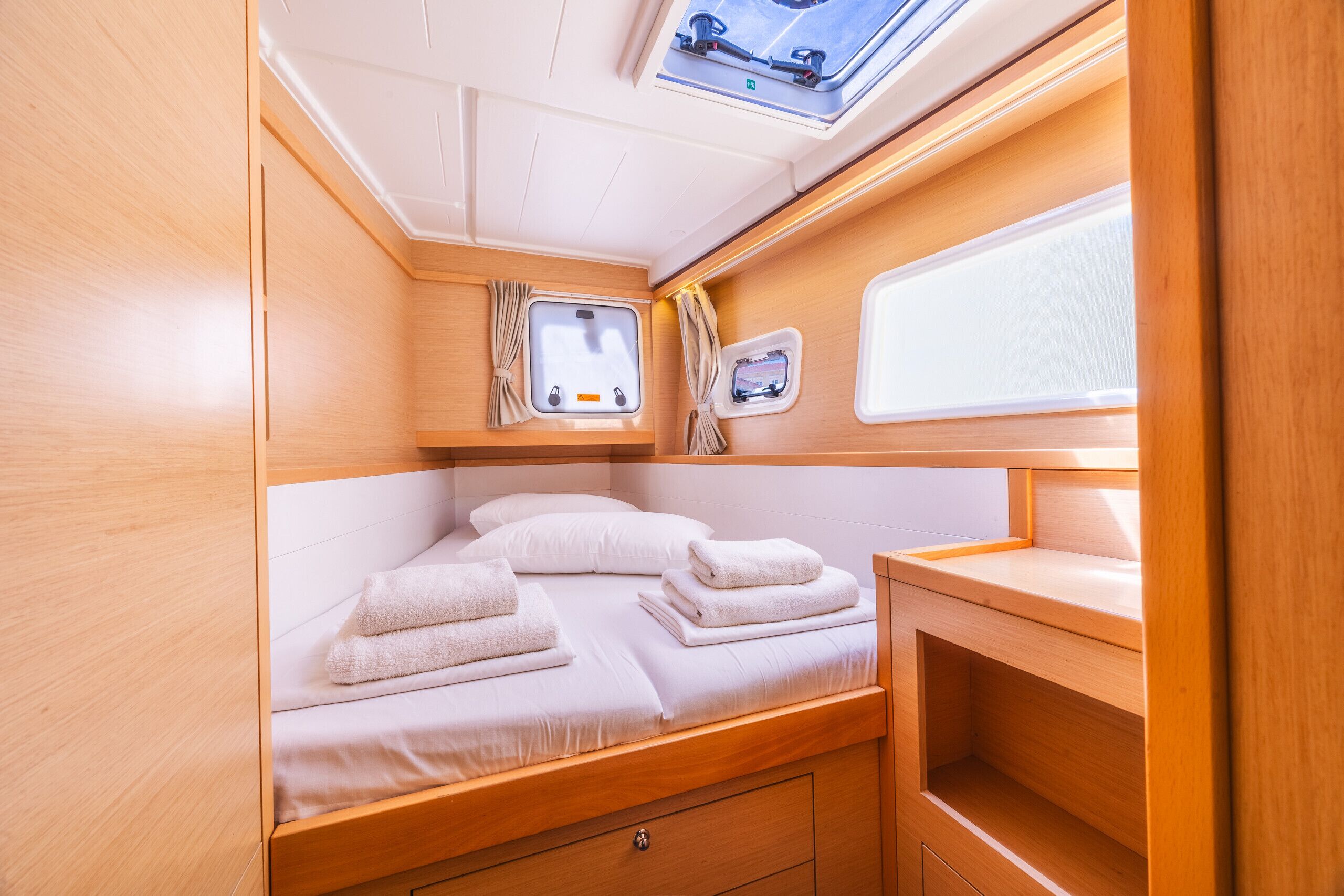 Ein gemütliches, helles Blockhäuschen mit einem Bett, einem kleinen Fenster und einem fest installierten Spülbecken.