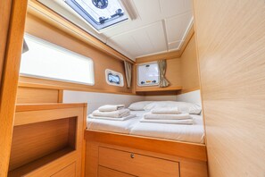 A compact, well-lit interior with a bed, a small window, and a control panel.