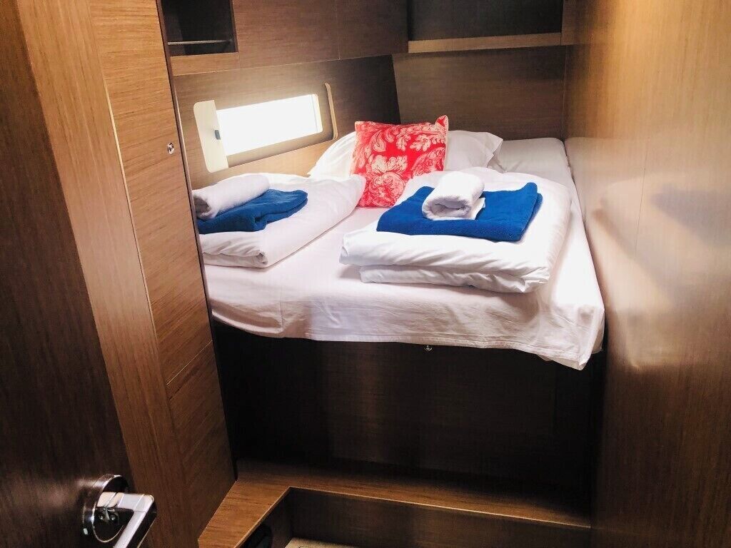 Ein kleines Zimmer mit Bett, kleinem Fenster und Tür.