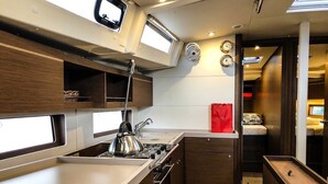 Una cucina compatta con fornello, lavandino e pensili in legno.