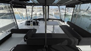 A boat's deck with a steering wheel, a table, and seating. - Sun-Kissed Sailing Adventure in Islas Sarónicas (Alimos)