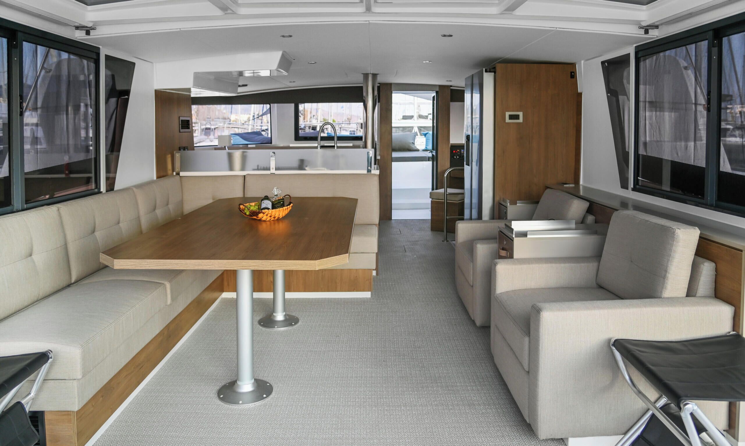 Un interior moderno con una mesa de comedor, asientos acolchados y ventanas amplias.