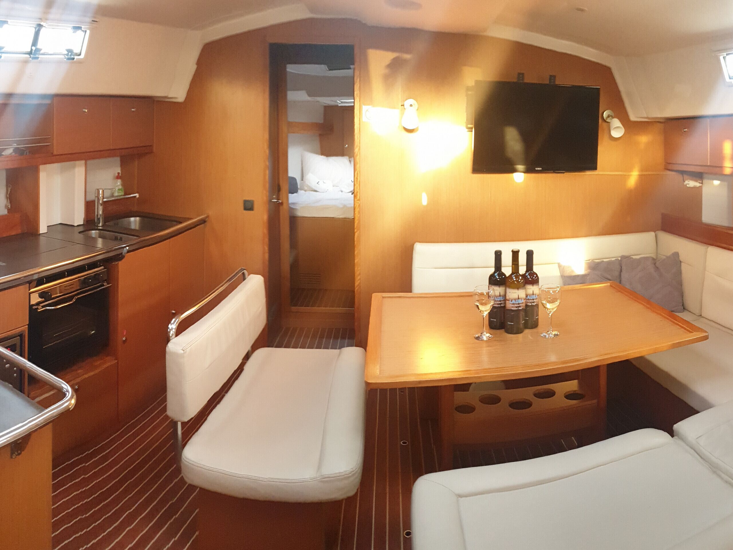 Un espacio interior compacto con kitchenette, zona de estar y televisor.
