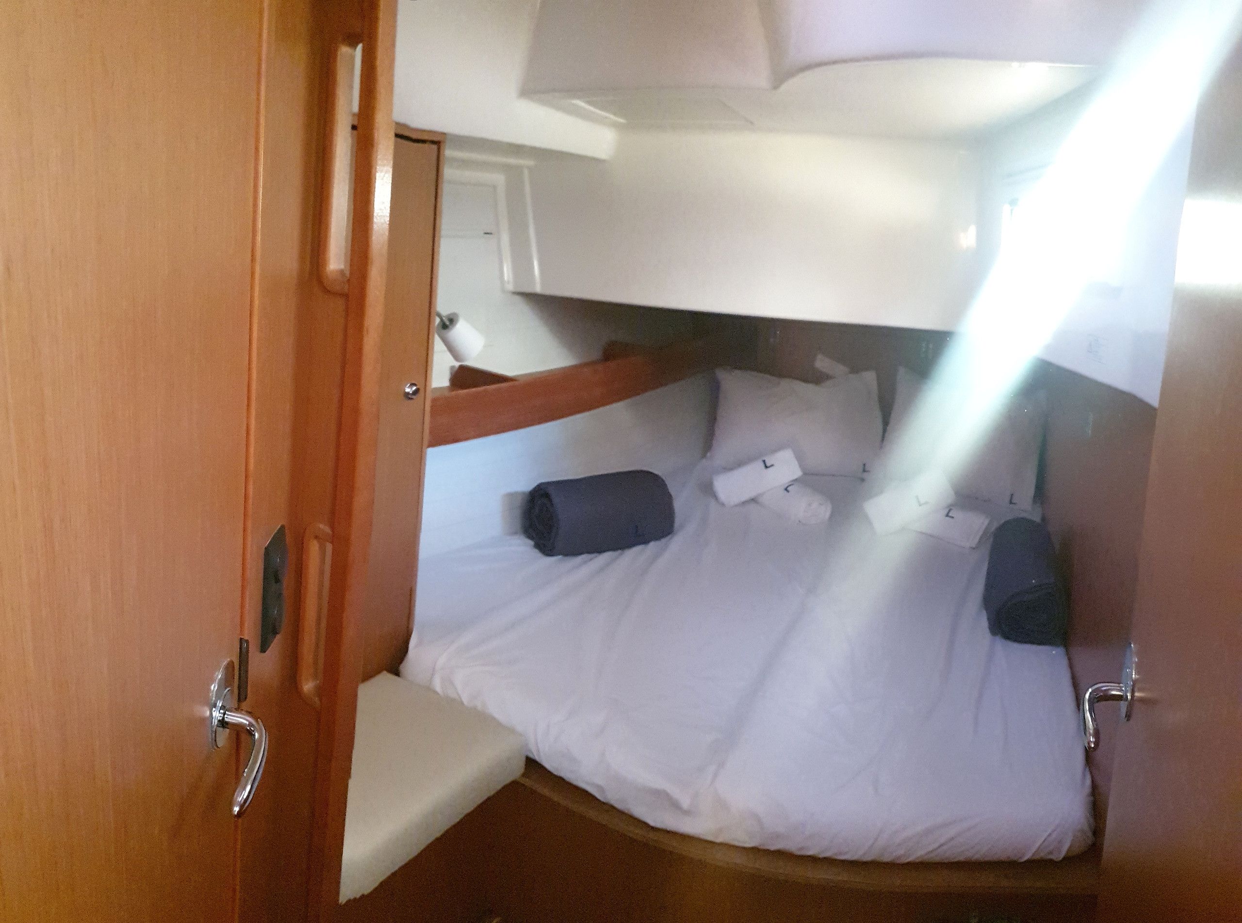 A compact cabin with a bunk bed, a small seating area, and a door leading to an adjacent room.