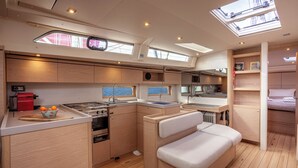 A compact kitchen with a stove, sink, and a small dining area. - Sun-Kissed Sailing Adventure in Islas Cícladas, Mykonos (Mykonos)