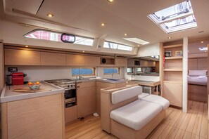 A compact kitchen with a stove, sink, and a small dining area. - Sun-Kissed Sailing Adventure in Islas Cícladas, Mykonos (Mykonos)