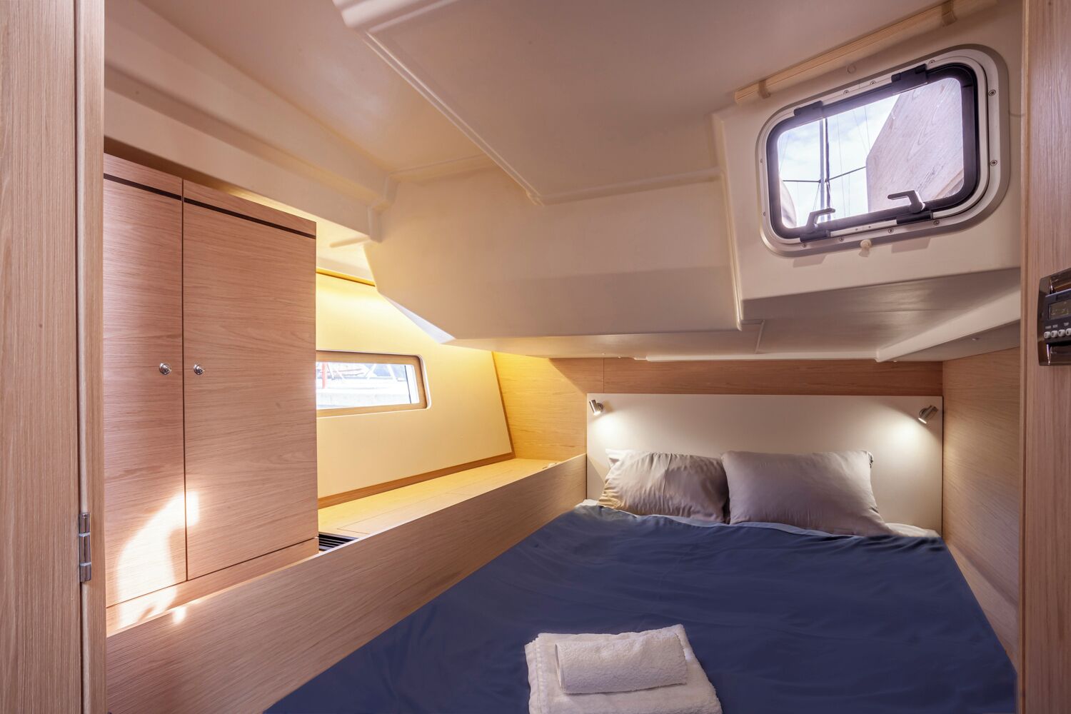 Una cabaña pequeña y bien iluminada con una cama, un ventanal y un armario.