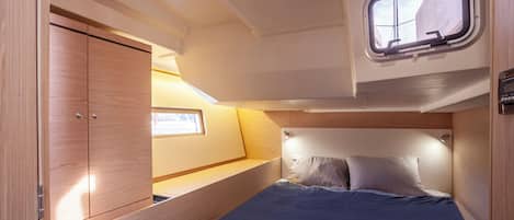 Una cabaña pequeña y bien iluminada con una cama, un ventanal y un armario.