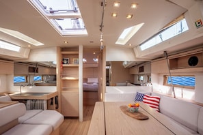 A modern RV interior with a kitchen, dining area, and sleeping quarters. - Sun-Kissed Sailing Adventure in Islas Cícladas, Mykonos (Mykonos)
