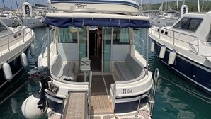 Un bateau doté d’un espace salon couvert, d’une petite table et d’une planche de wakeboard.