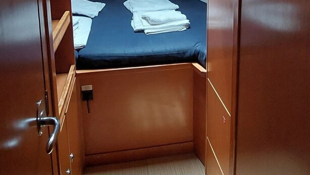 A compact room with a bunk bed, a skylight, and a small window. - Sun-Kissed Sailing Adventure in Islas Sarónicas (Alimos)