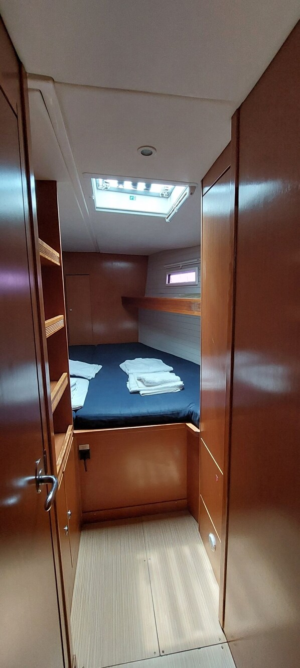 Ein kleines Zimmer mit Etagenbett, einem Dachfenster und einem kleinen Fenster.