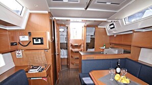 Un interior compacto con comedor, asientos, una pequeña kitchenette y un panel de control.