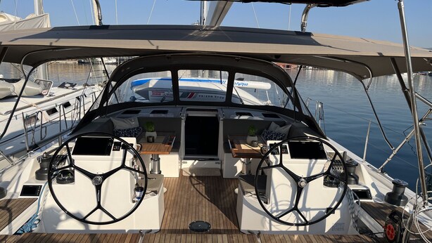 Das Deck eines Bootes mit Steuer, Armaturen und Sitzgelegenheiten.