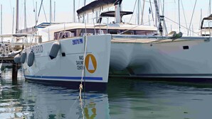 A white yacht with 'NATIONAL SAILING CENTER' and 'HYBRID' written on its side, docked at a marina with other boats. - Sun-Kissed Sailing Adventure in Northern Croatia (Punat)