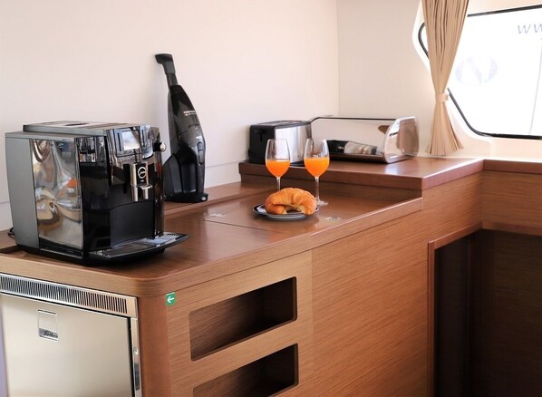 Eine Küchenzeile mit Kaffeemaschine, Toaster und zwei Gläsern Orangensaft auf der Arbeitsplatte.
