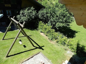 A grassy area with a wooden swing set and a small sandbox. - Majelas Heiti Appartement/Fewo, Dusche und Bad, WC 6-Bettwohnung by Interhome (Gsteig bei Gstaad)