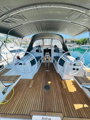 A boat deck with a covered area, two steering wheels, and a sign reading 'AVISA'. - Sun-Kissed Sailing Adventure in Northern Croatia (Novi Vinodolski)
