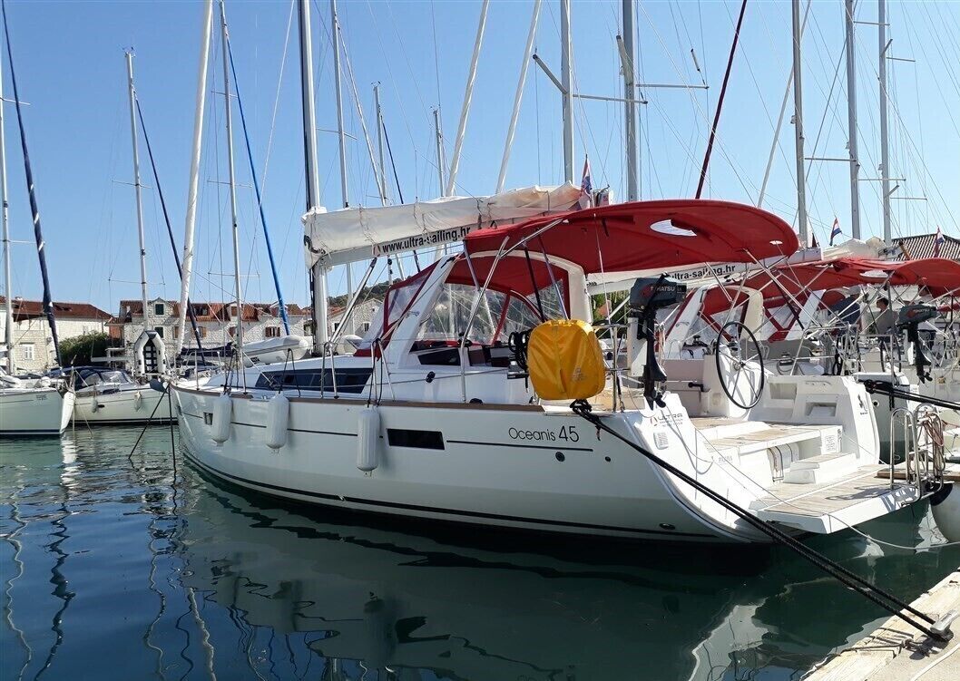 A marina with several sailboats docked, including one named 'Oceanis 45'.