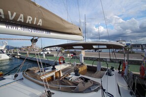 Ein Yachthafen mit vertäuten Booten, ein überdachter Bereich mit Plane und eine sichtbare Website-URL.