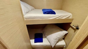 A bunk bed with a blue towel on the top bunk and a smartphone on the lower bunk. - Sibenik Sun-soaked Sailing: A Luxurious Croatian Voyage (Pirovac)