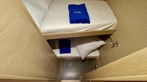 A small, enclosed room with a bunk bed, a blue towel on the top bunk, and a small shelf with a blue item. - Sibenik Sun-soaked Sailing: A Luxurious Croatian Voyage (Pirovac)
