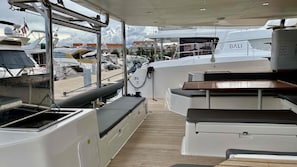 A boat deck with seating, a control station, and a view of other boats. - Sibenik Sun-soaked Sailing: A Luxurious Croatian Voyage (Pirovac)