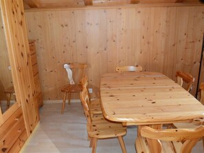 Une salle à manger en bois, avec une grande table et des chaises, un buffet en bois et un plafond en bois.