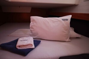A bed with a white pillow and a folded towel. - Sibenik Sun-soaked Sailing: A Luxurious Croatian Voyage (Pirovac)