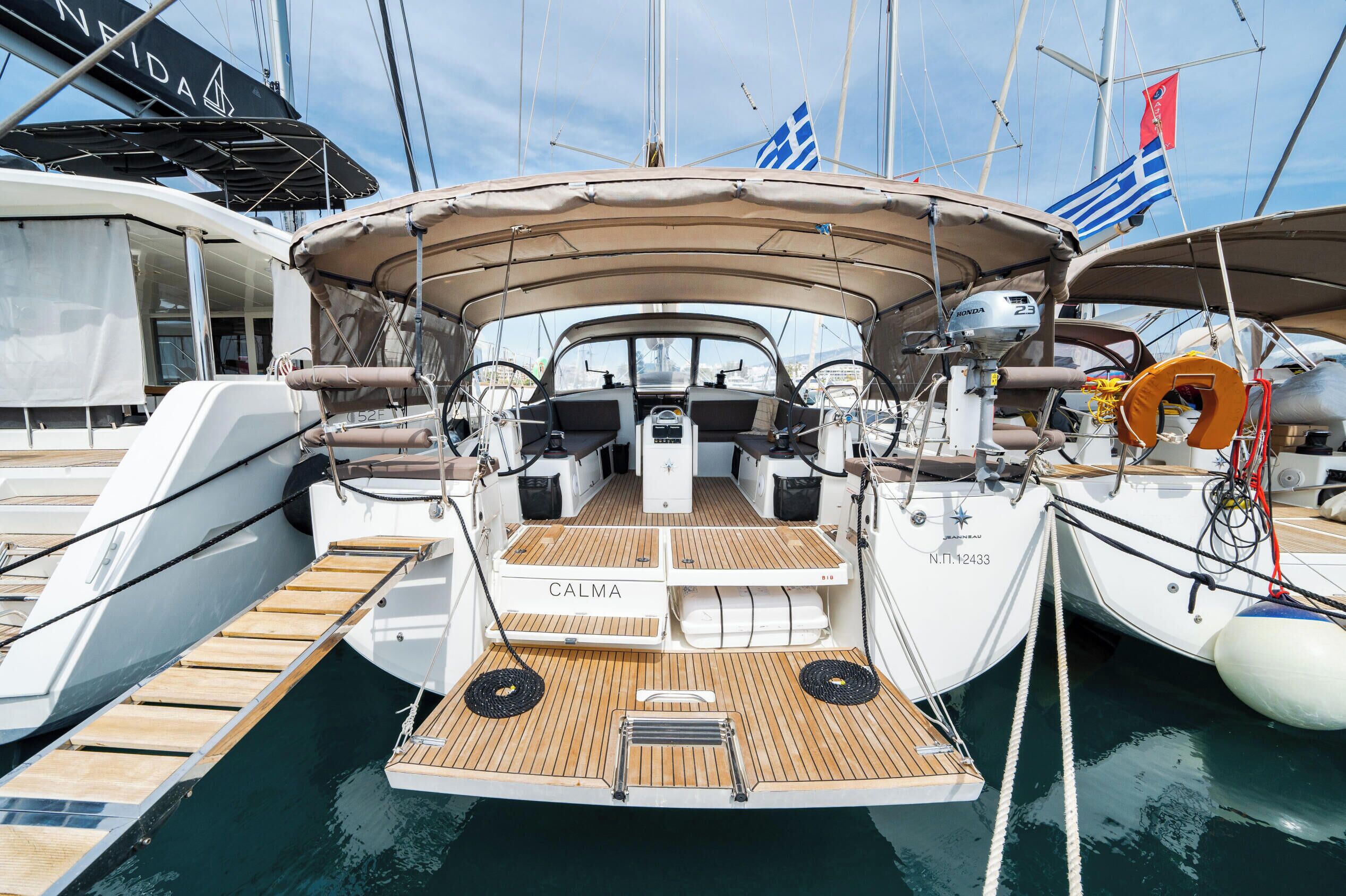 Eine Yacht mit abgedecktem Deck, Steuer und Rettungsring.