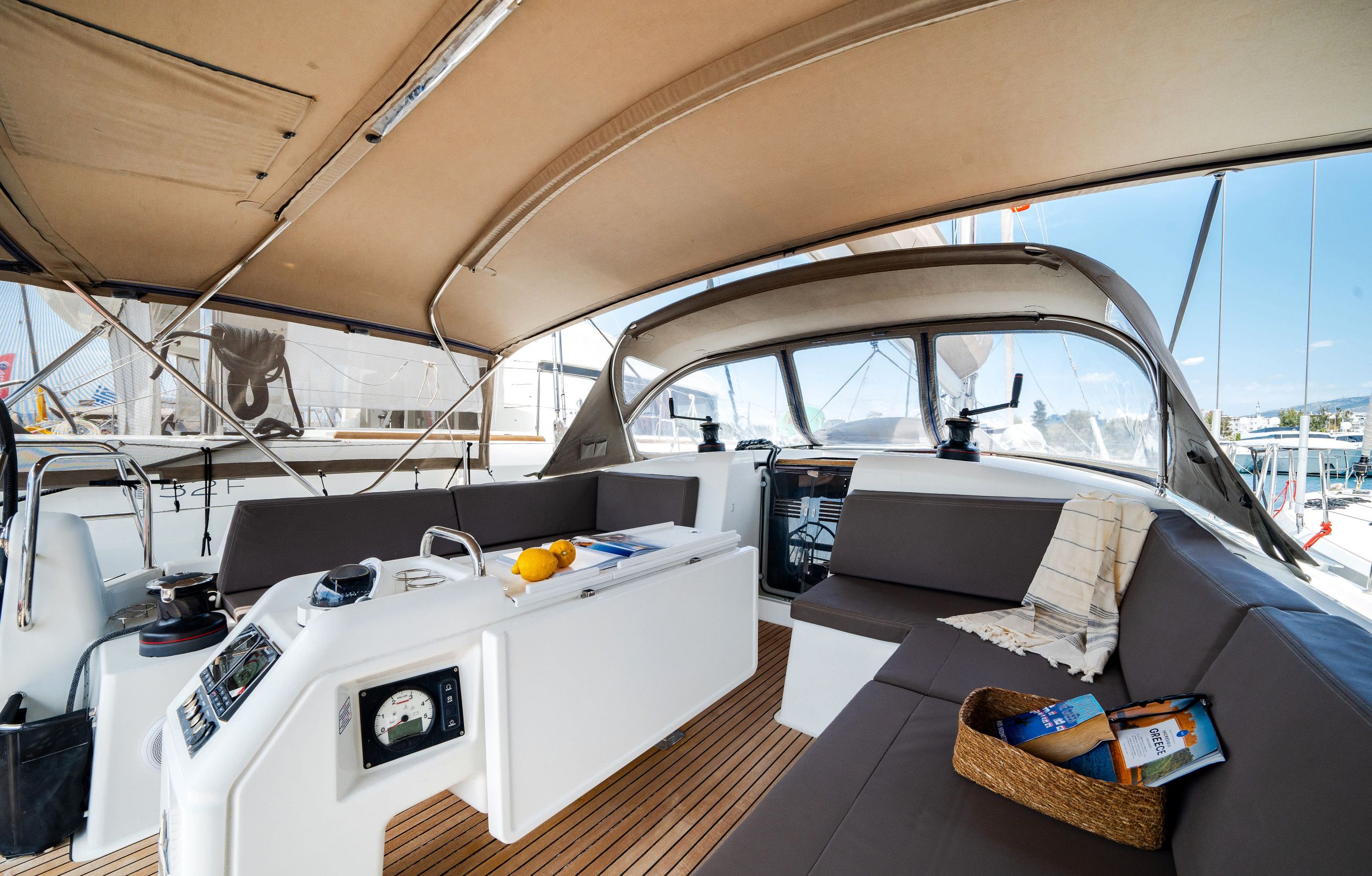 L'intérieur d'un bateau, avec un panneau de commande, un espace salon et une vue sur le port de plaisance.