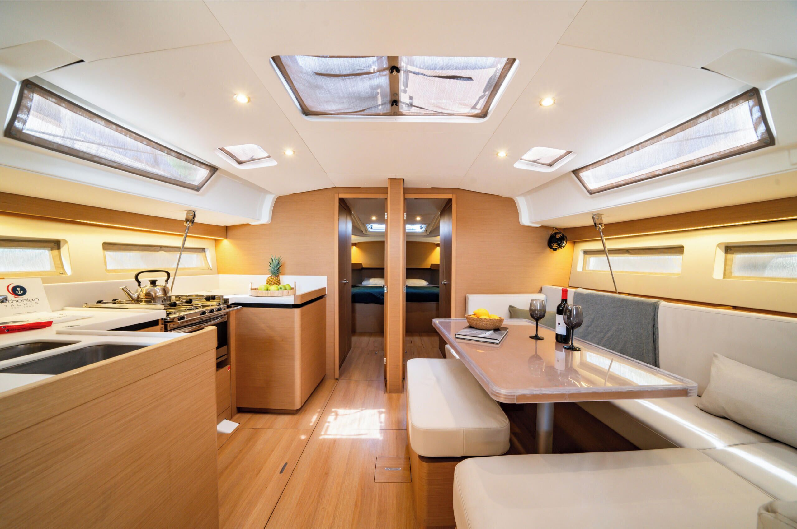 A compact kitchen with a stove, sink, and a small dining area with a bench and table.