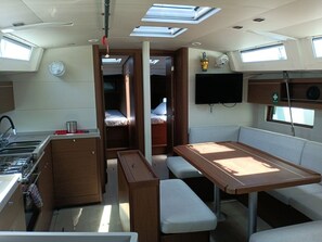A compact RV interior with a kitchenette, a dining area, and a sleeping berth. - Sun-Kissed Sailing Adventure in the Sporades Islands from Volos, Thessaly (Volos)