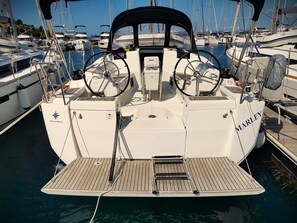 A boat named 'MARLEY' docked at a marina with multiple other boats, a steering wheel, and a control panel. - Sun-Kissed Sailing Adventure in Zadar, Croatia (Drage)