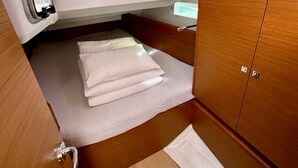 Un espacio interior compacto con una litera, un mueble pequeño y una ventana.