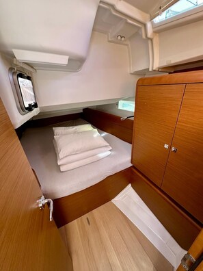 A compact interior with a bunk bed, a small cabinet, and a window. - Sun-Kissed Sailing Adventure in Zadar, Croatia (Drage)