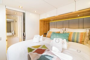 A modern hotel room with a large bed, a wooden headboard, and a mirror. - Sun-Kissed Sailing Adventure in Split, Croatia (Kaštel Gomilica)