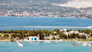 Un pueblo costero con un puerto deportivo, edificios y un puente.