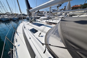 A marina with multiple sailboats docked, featuring a white deck with a small window and a covered area. - Sun-Kissed Sailing Adventure in Zadar, Croatia (Zadar)