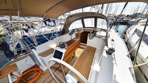 Cubierta de barco con timón, panel de control y dispositivo Garmin.