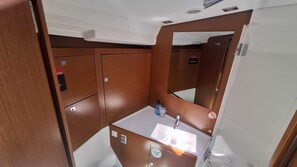 A compact bathroom with a sink, mirror, and storage cabinets.