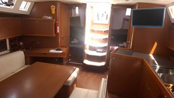 A compact interior with a kitchenette, a small seating area, and a window providing natural light.