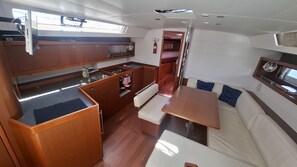 A compact galley with a sink, stove, and storage cabinets.