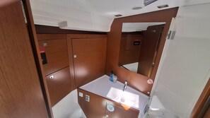 Un baño pequeño con lavamanos, espejo y armarios de almacenamiento.
